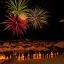 People watching fireworks above a mountain village.